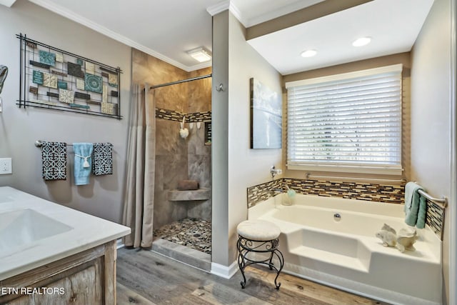 bathroom with hardwood / wood-style floors, vanity, crown molding, and separate shower and tub