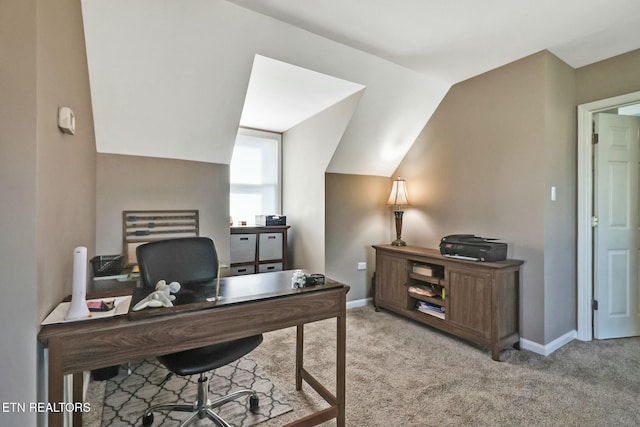 home office featuring light carpet and lofted ceiling