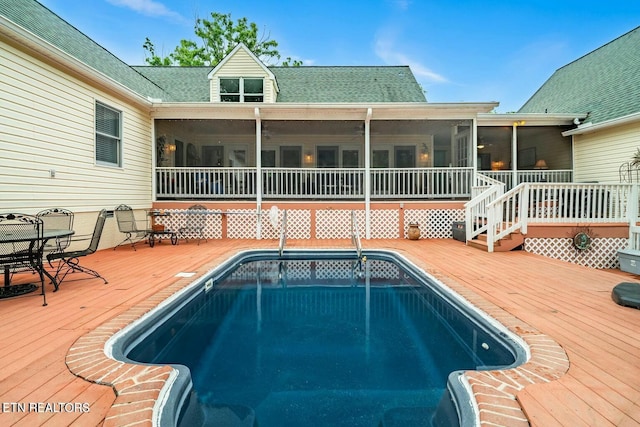 view of swimming pool with a deck and a sunroom