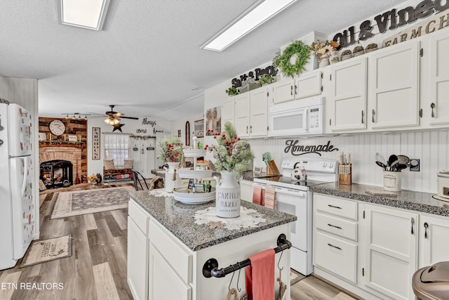 kitchen featuring ceiling fan, white appliances, white cabinetry, and a textured ceiling