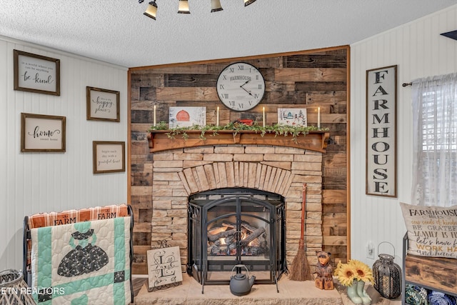 room details with a textured ceiling, a stone fireplace, and wooden walls