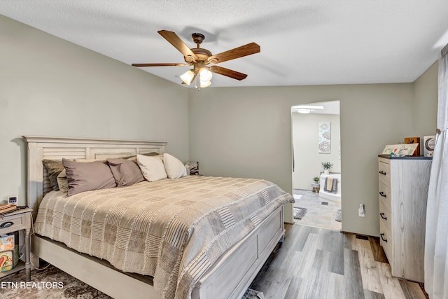 bedroom with ceiling fan, a textured ceiling, and light hardwood / wood-style floors