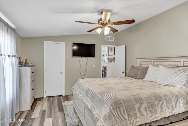 bedroom with ceiling fan, light hardwood / wood-style floors, and lofted ceiling