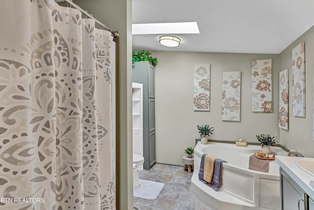 full bathroom with toilet, a skylight, separate shower and tub, and vanity