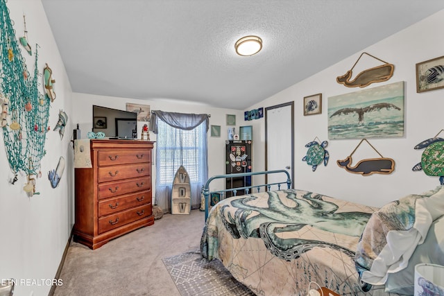 bedroom with a textured ceiling, lofted ceiling, and light colored carpet