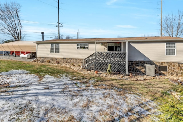 back of property featuring central AC unit and a carport