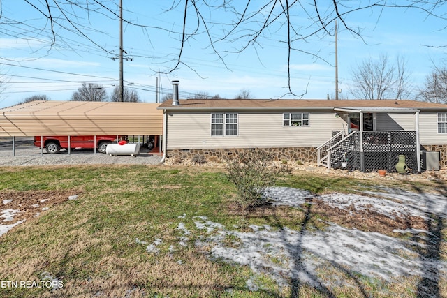 back of property featuring central air condition unit, a lawn, and a carport