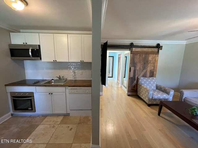2733 Jersey Ave Unit C302, Knoxville, TN 37919 - kitchen with a barn door, white cabinetry, sink, and stainless steel appliances