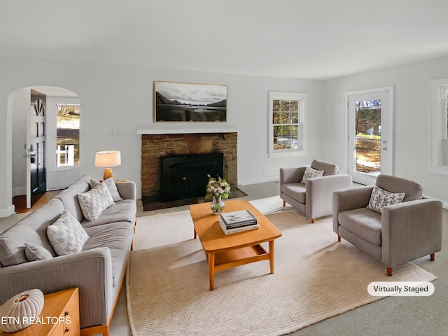 carpeted living room featuring plenty of natural light and a fireplace