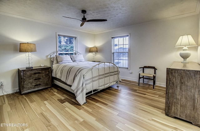 bedroom with ceiling fan, light hardwood / wood-style flooring, a textured ceiling, and ornamental molding