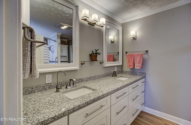 bathroom with crown molding, vanity, a textured ceiling, and hardwood / wood-style flooring