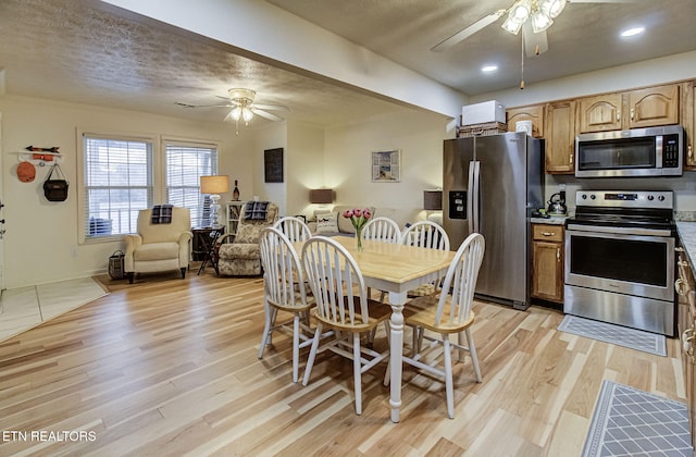 dining room featuring light hardwood / wood-style floors and a textured ceiling