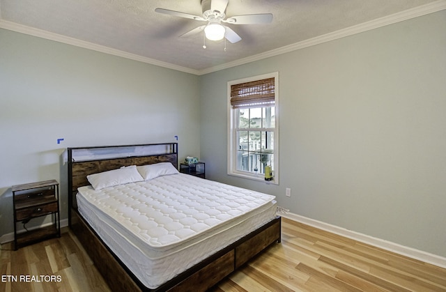 bedroom with wood-type flooring, a textured ceiling, ceiling fan, and ornamental molding