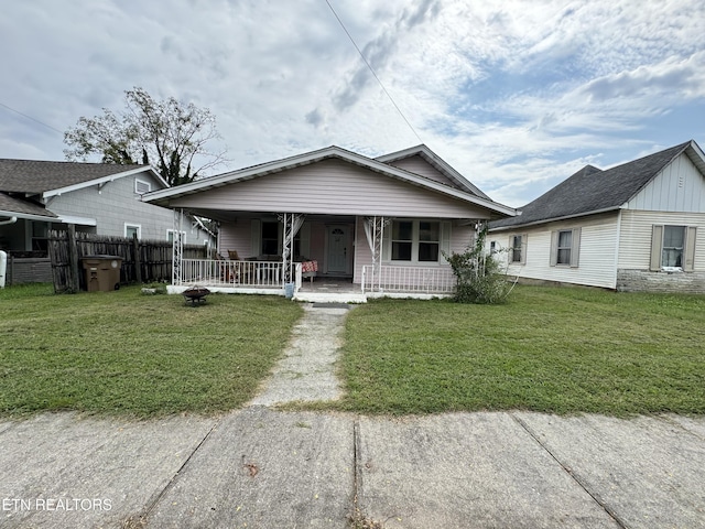 bungalow-style house featuring covered porch and a front yard