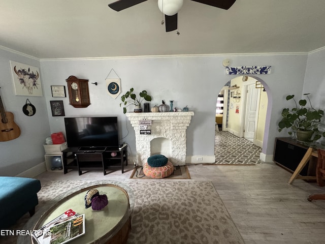 living room featuring ceiling fan, wood-type flooring, and crown molding