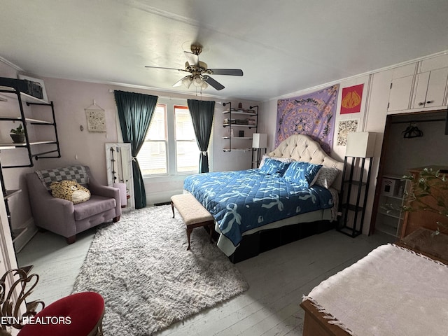 bedroom with ceiling fan, light hardwood / wood-style floors, and ornamental molding