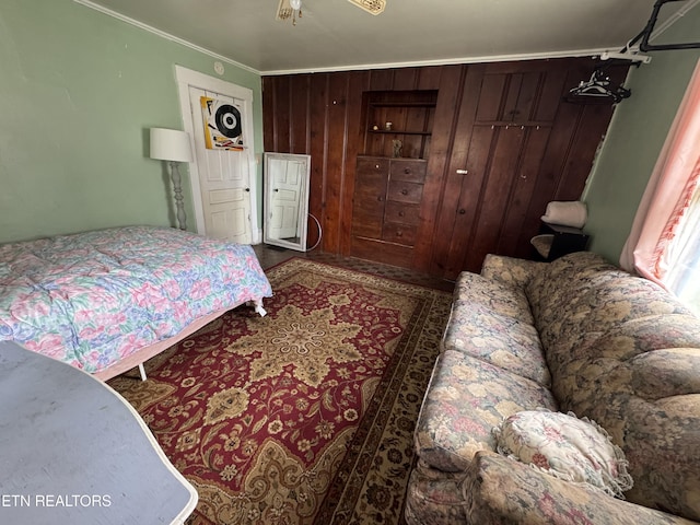 bedroom with crown molding and wooden walls