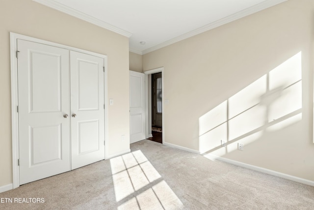 unfurnished bedroom with light carpet, ornamental molding, and a closet