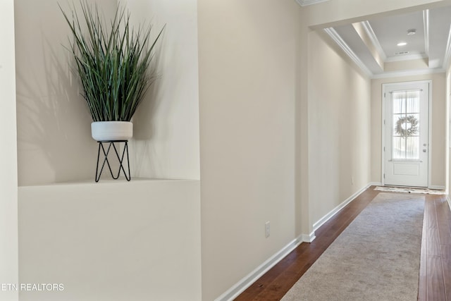 hallway featuring a tray ceiling, ornamental molding, and dark hardwood / wood-style floors