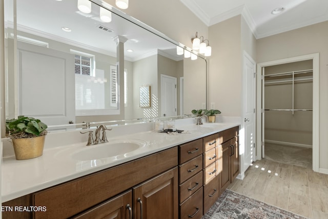 bathroom with hardwood / wood-style flooring, vanity, and crown molding