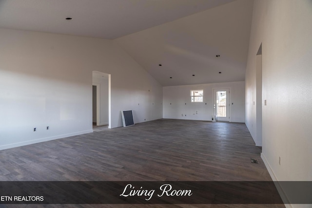 unfurnished living room featuring dark wood-type flooring and high vaulted ceiling