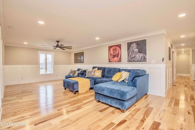 living room featuring ceiling fan, light hardwood / wood-style floors, and ornamental molding