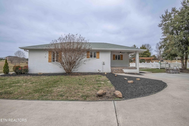 view of front of house featuring a patio area, ceiling fan, and a front yard