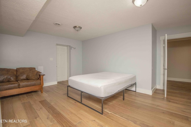 bedroom featuring a textured ceiling and hardwood / wood-style flooring