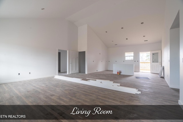 unfurnished living room with wood-type flooring and high vaulted ceiling