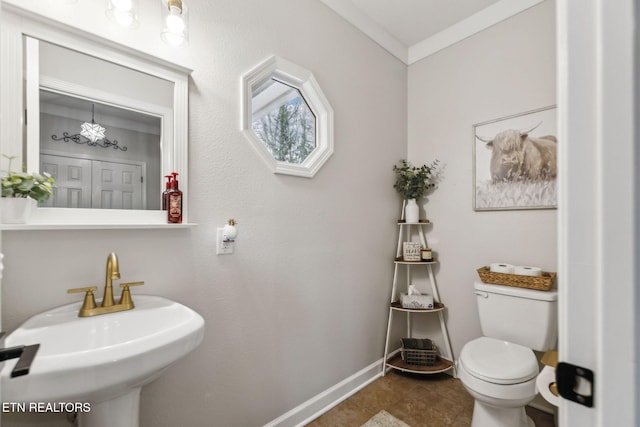 bathroom featuring crown molding, toilet, and sink