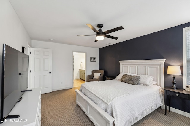 carpeted bedroom with ensuite bath and ceiling fan