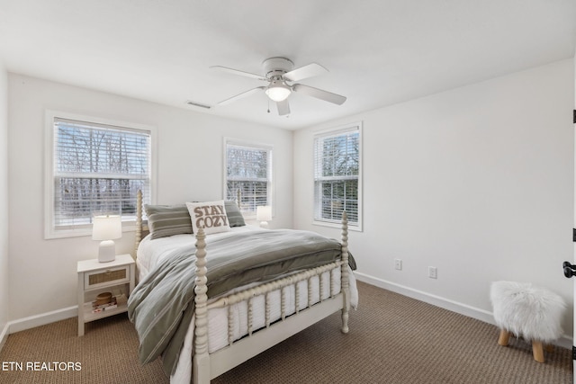 carpeted bedroom with multiple windows and ceiling fan