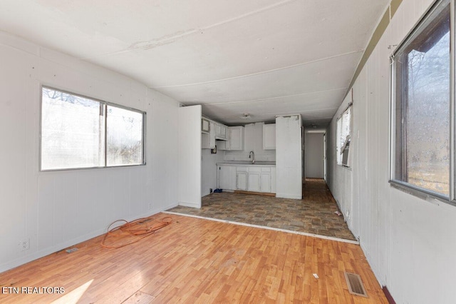 unfurnished living room featuring light hardwood / wood-style flooring and sink