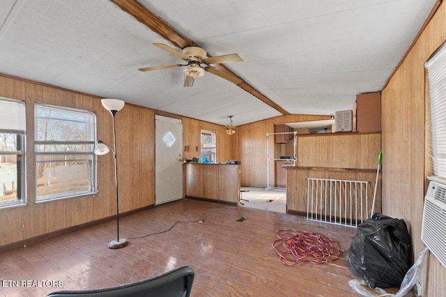 interior space featuring vaulted ceiling with beams, ceiling fan, and wooden walls