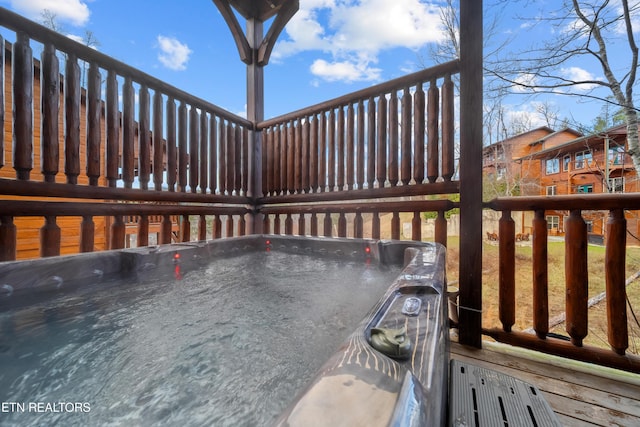 wooden deck with a hot tub