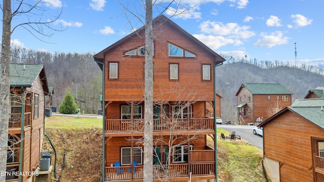 back of house featuring a mountain view, a balcony, and cooling unit