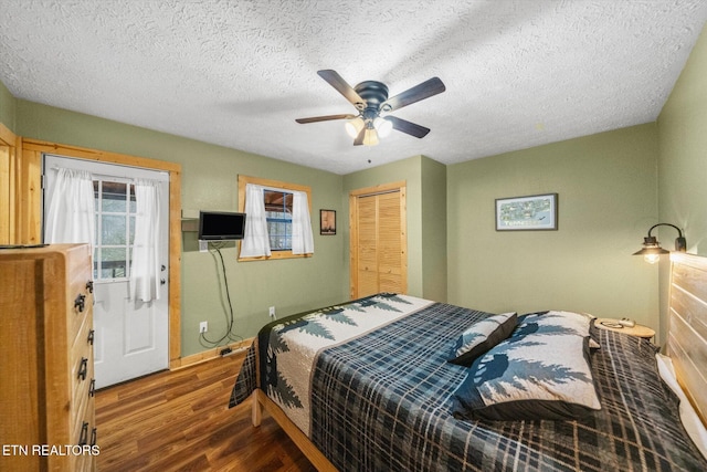 bedroom featuring dark hardwood / wood-style flooring, ceiling fan, a closet, and a textured ceiling