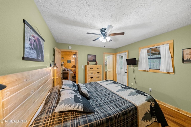 bedroom featuring ceiling fan, wood-type flooring, and a textured ceiling