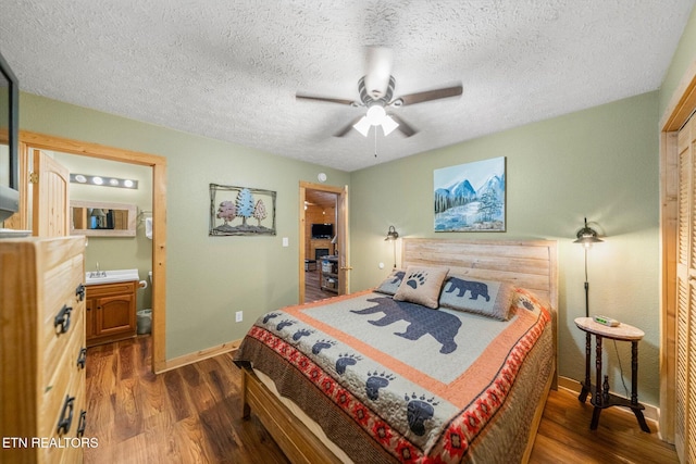 bedroom with ensuite bathroom, a textured ceiling, ceiling fan, dark wood-type flooring, and a closet