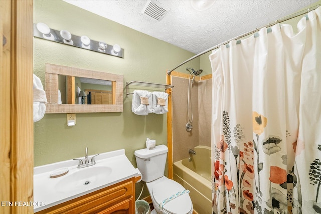 full bathroom featuring shower / tub combo with curtain, vanity, a textured ceiling, and toilet