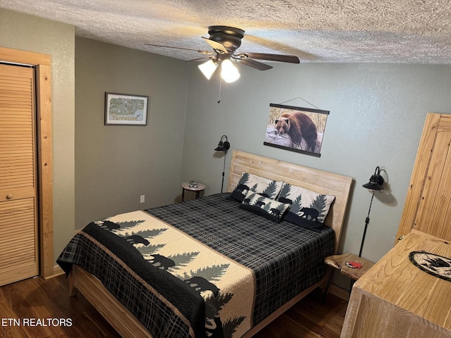 bedroom with dark wood-style floors, a ceiling fan, and a textured ceiling