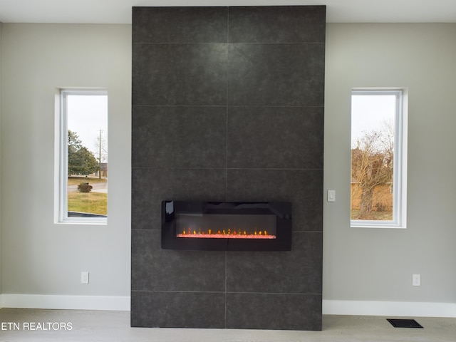 details with visible vents, baseboards, and a tile fireplace
