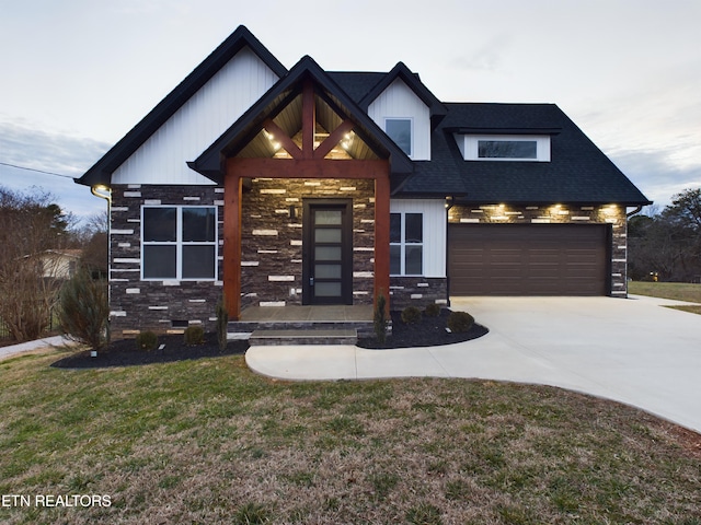 view of front facade featuring stone siding, concrete driveway, a front lawn, and a shingled roof