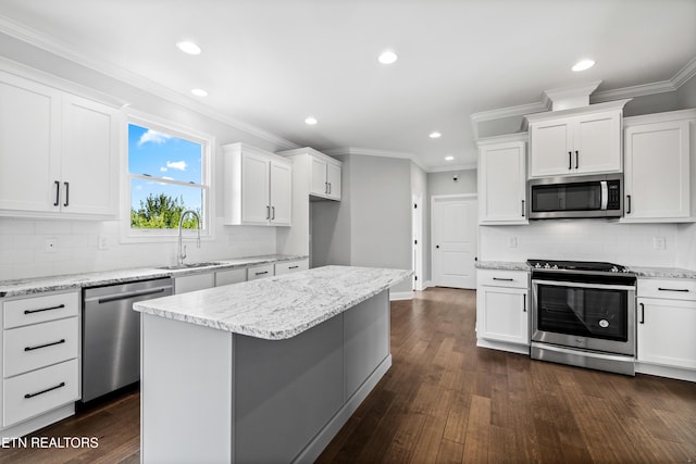 kitchen featuring white cabinetry, sink, a center island, and appliances with stainless steel finishes