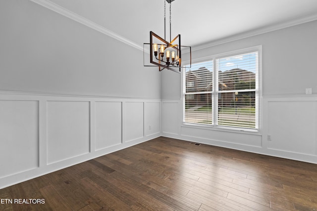 unfurnished dining area featuring crown molding, dark hardwood / wood-style flooring, and an inviting chandelier