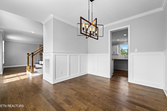 unfurnished dining area with dark hardwood / wood-style flooring, ornamental molding, and a chandelier