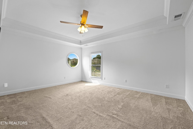 carpeted empty room featuring a tray ceiling, ceiling fan, and ornamental molding