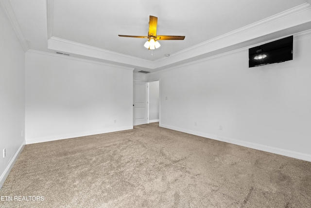 empty room with carpet flooring, a raised ceiling, ceiling fan, and ornamental molding