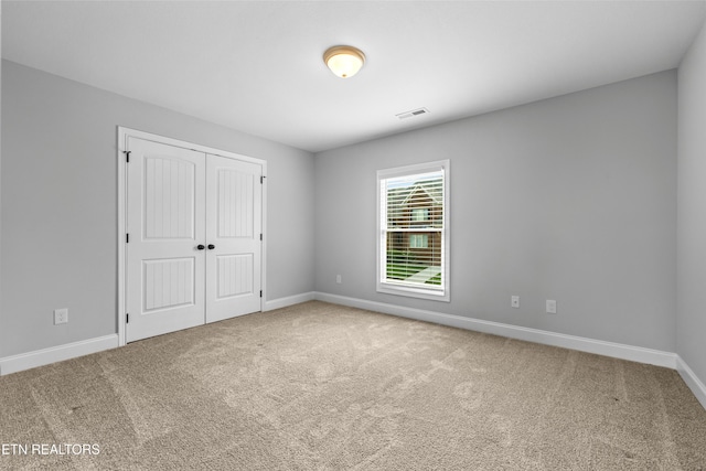 unfurnished bedroom featuring carpet and a closet