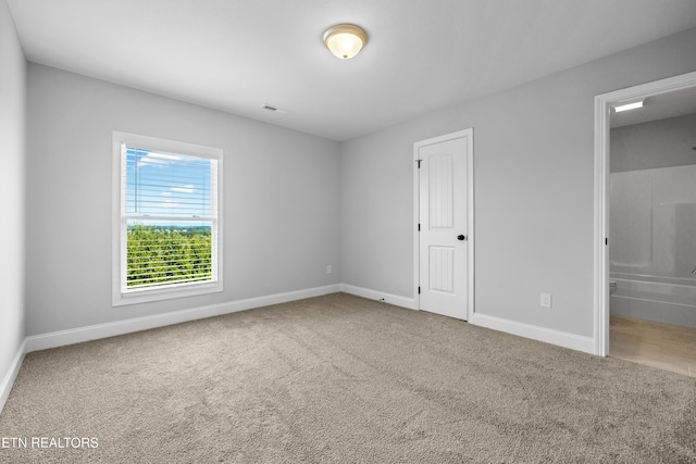 unfurnished bedroom featuring carpet flooring and connected bathroom